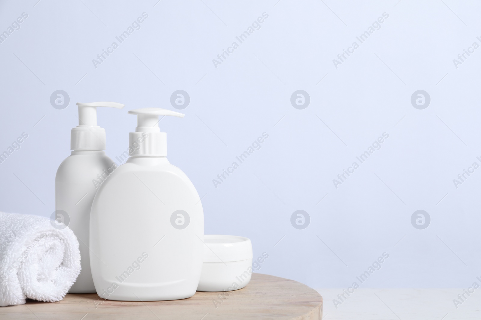 Photo of Different cosmetic products and towel on white wooden table. Space for text