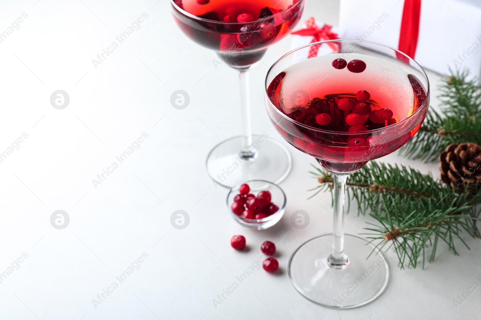 Photo of Delicious Christmas cocktail with liqueur on white table. Space for text