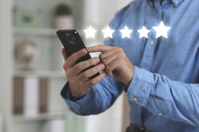 Image of Man leaving service feedback with smartphone at home, closeup. Stars over device