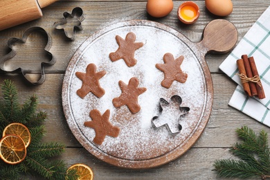 Photo of Flat lay composition with homemade gingerbread man cookies on wooden table
