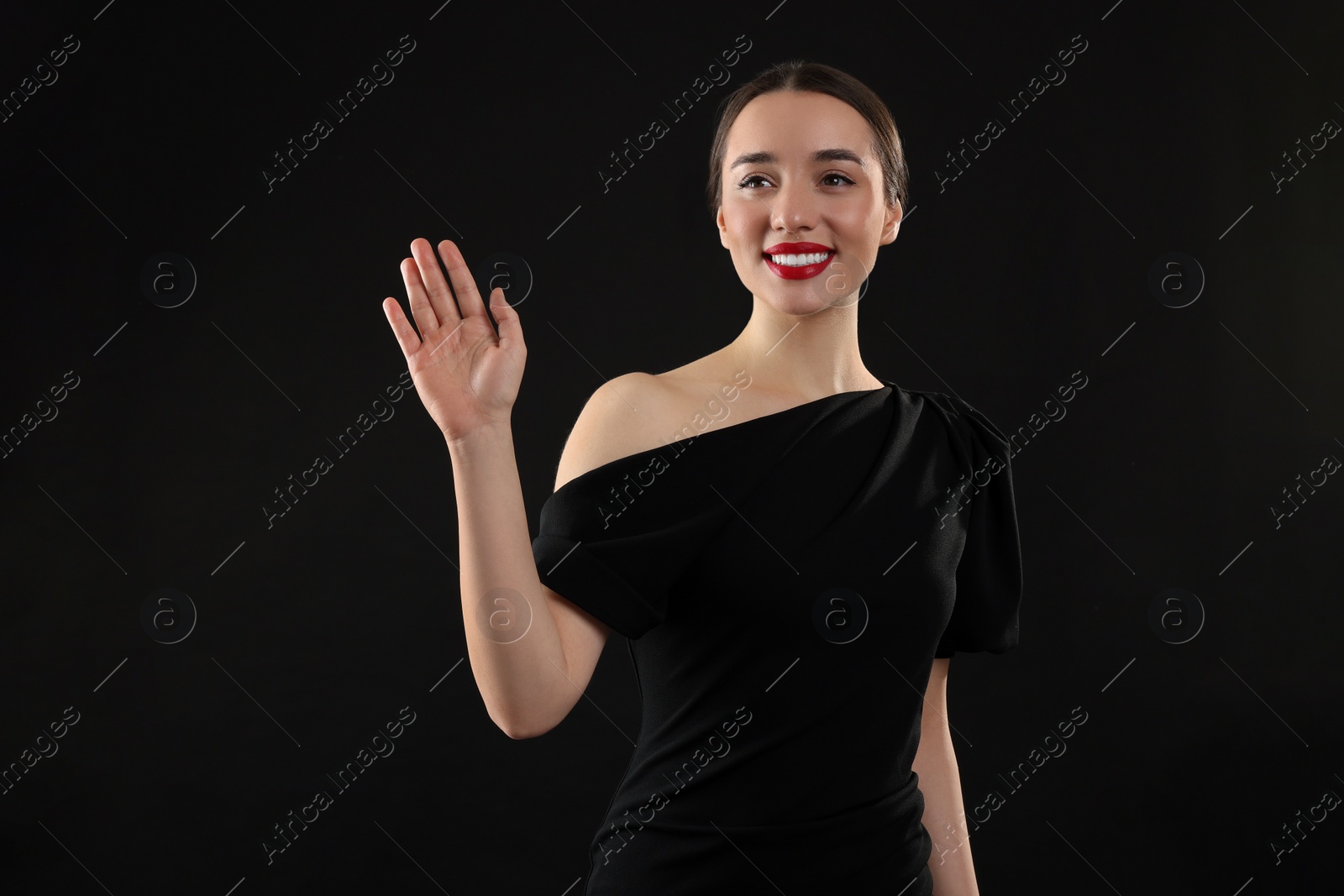 Photo of Beautiful young woman in elegant dress on black background