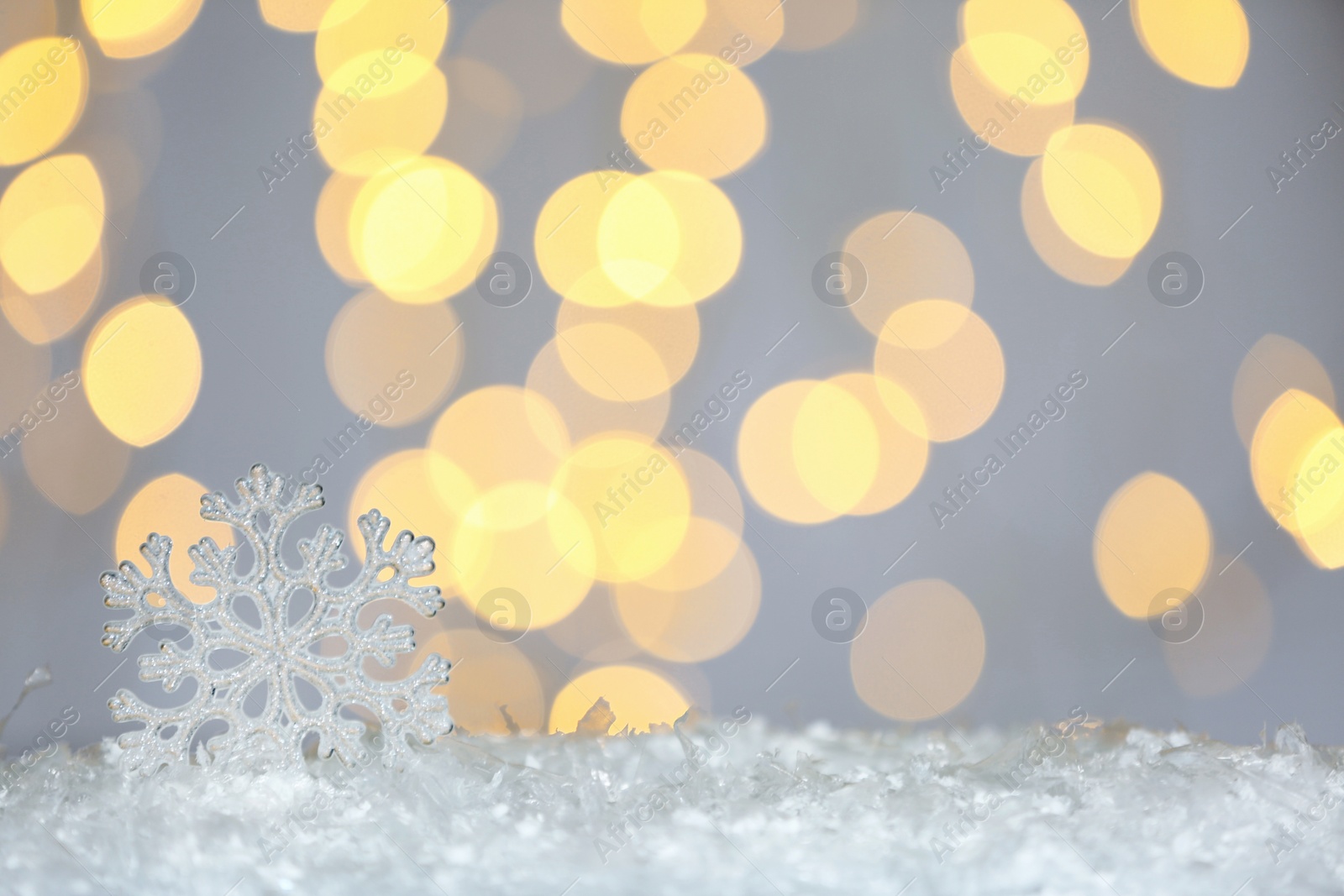 Photo of Beautiful decorative snowflake against blurred festive lights, space for text