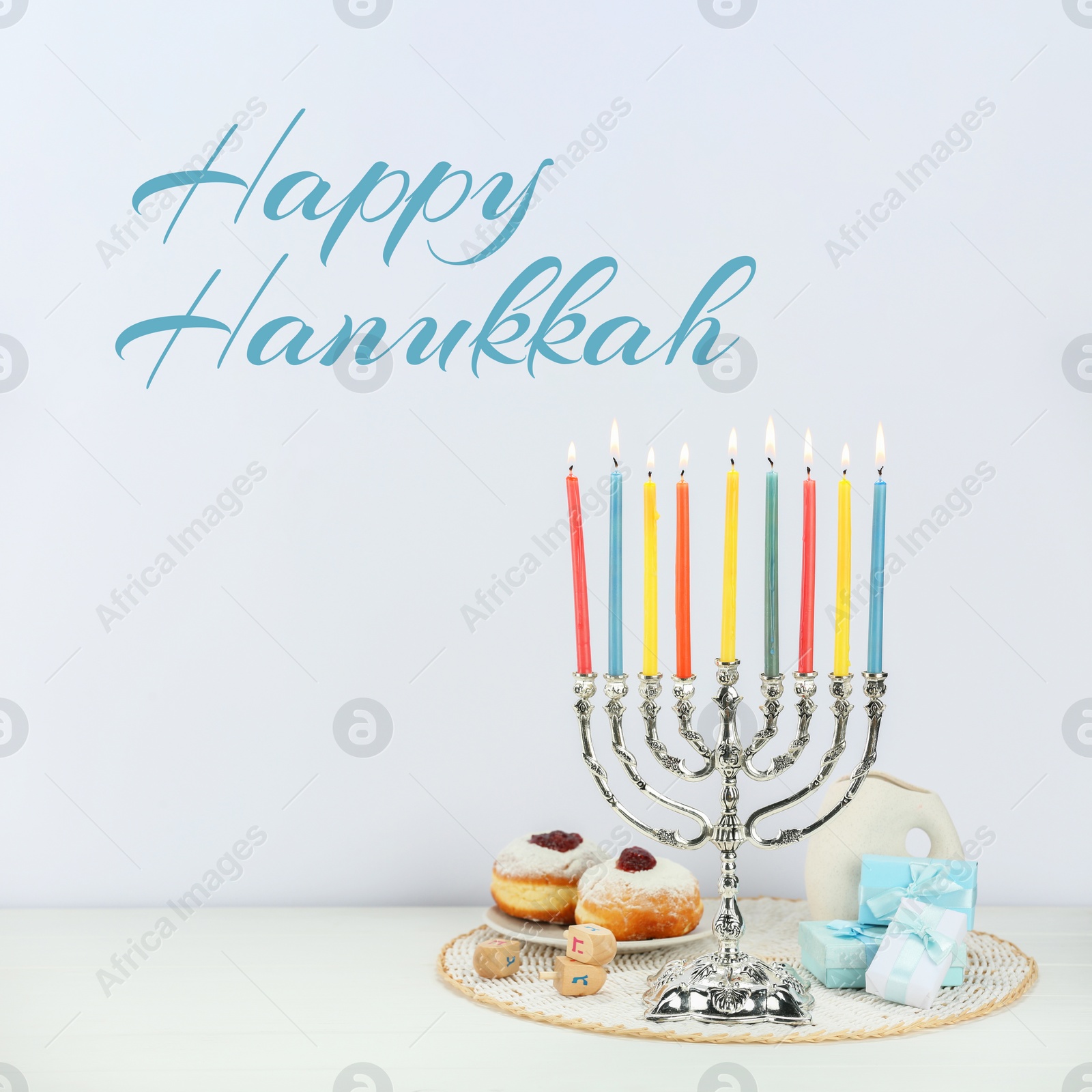 Image of Happy Hanukkah. Menorah, donuts, gifts and dreidels on white table