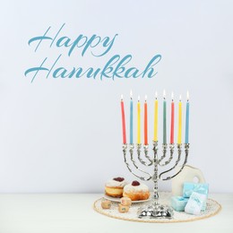 Image of Happy Hanukkah. Menorah, donuts, gifts and dreidels on white table