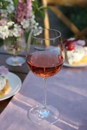 Glass of wine on table served for romantic date in garden
