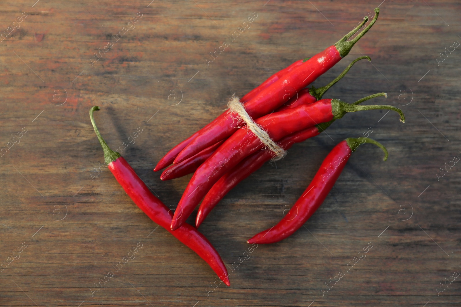 Photo of Fresh ripe chili peppers on wooden table, flat lay