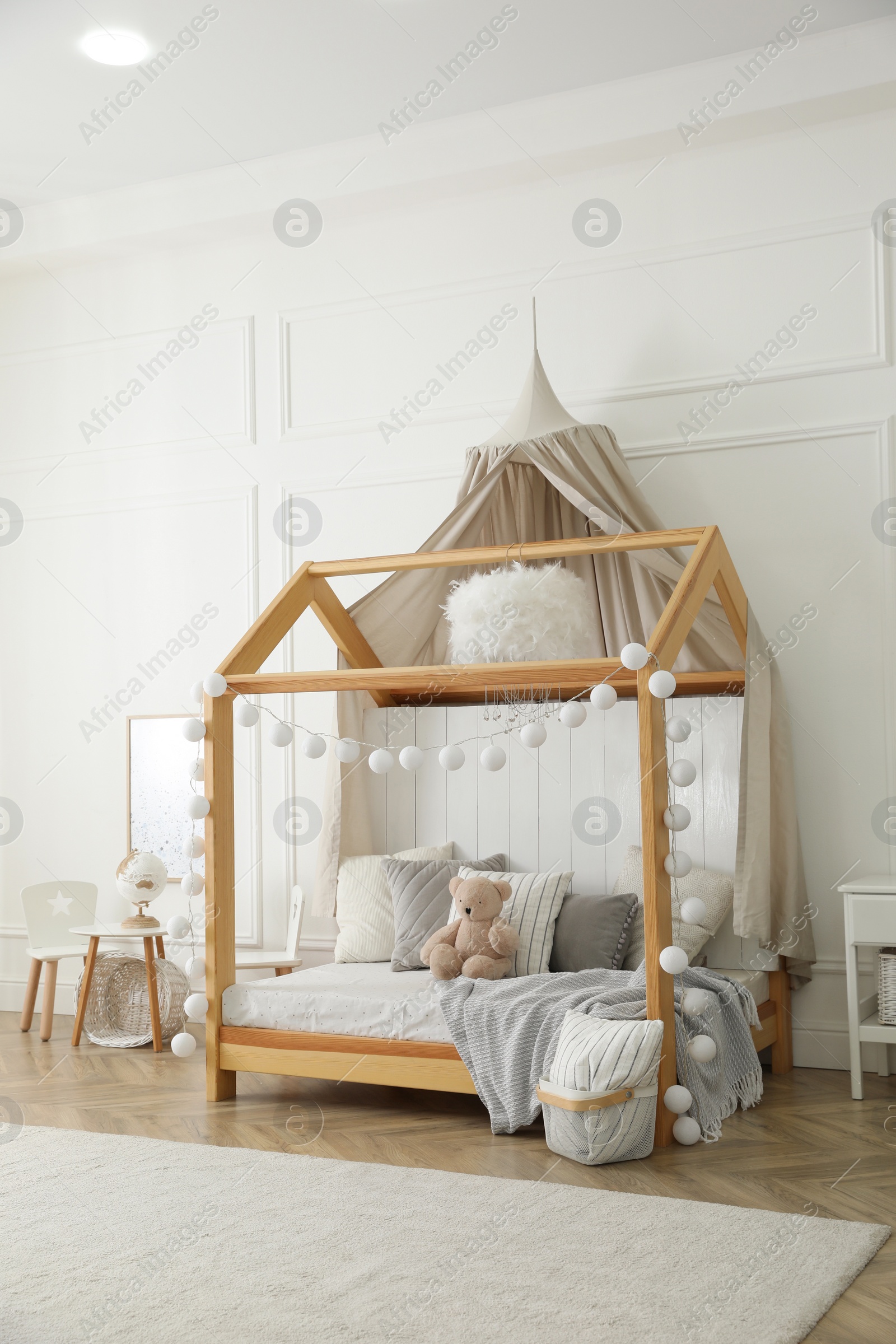 Photo of Stylish room for kid with house bed. Interior design