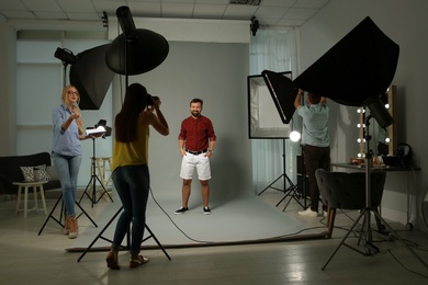 Professional team working with model in photo studio