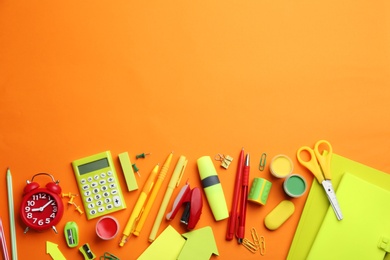 Photo of Different bright school stationery on orange background, flat lay. Space for text