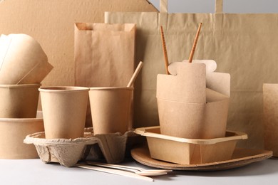 Eco friendly food packaging. Paper containers, tableware and bag on white table