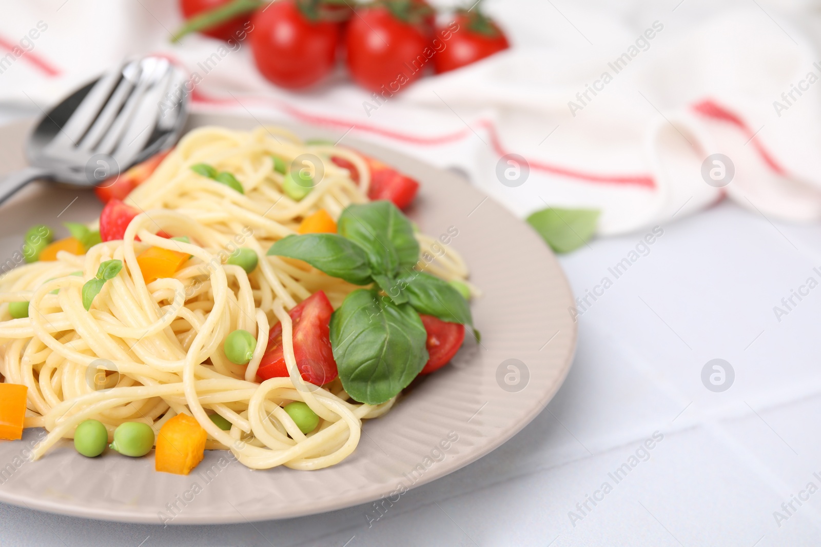 Photo of Plate of delicious pasta primavera served on white table, closeup