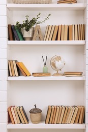 Collection of books and decor elements on shelves indoors