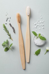Flat lay composition with toothbrushes and herbs on white background