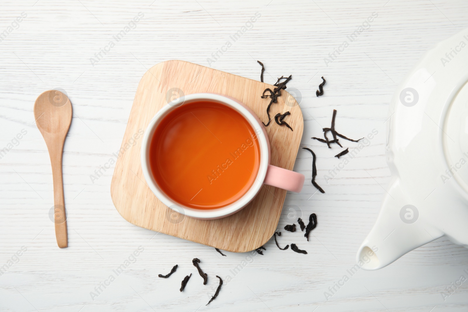 Photo of Cup of black tea on wooden table, top view