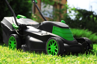 Photo of Lawn mower on green grass in garden