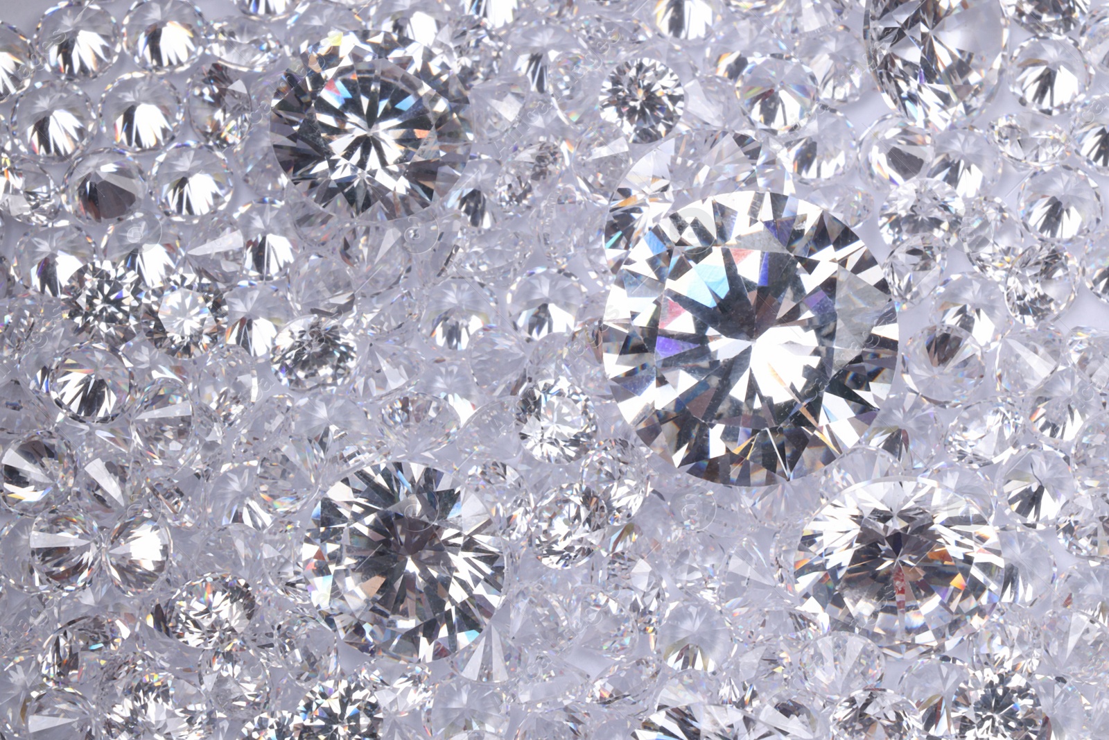 Photo of Many beautiful shiny diamonds as background, top view