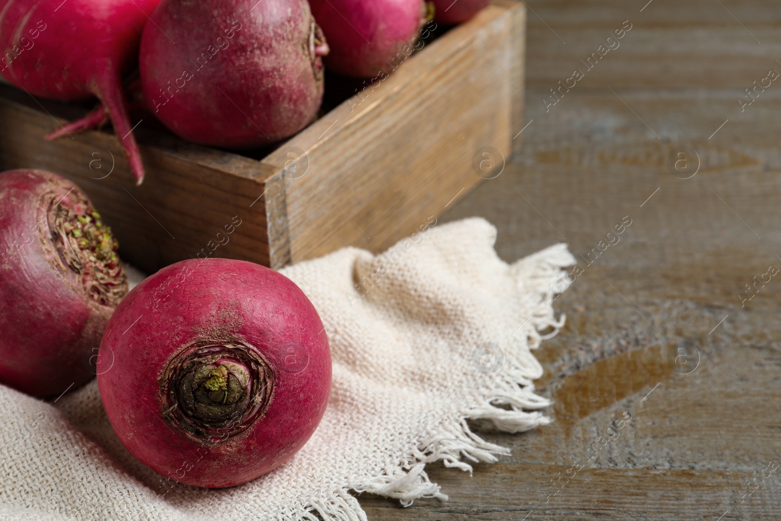 Photo of Red raw turnips on wooden table, closeup