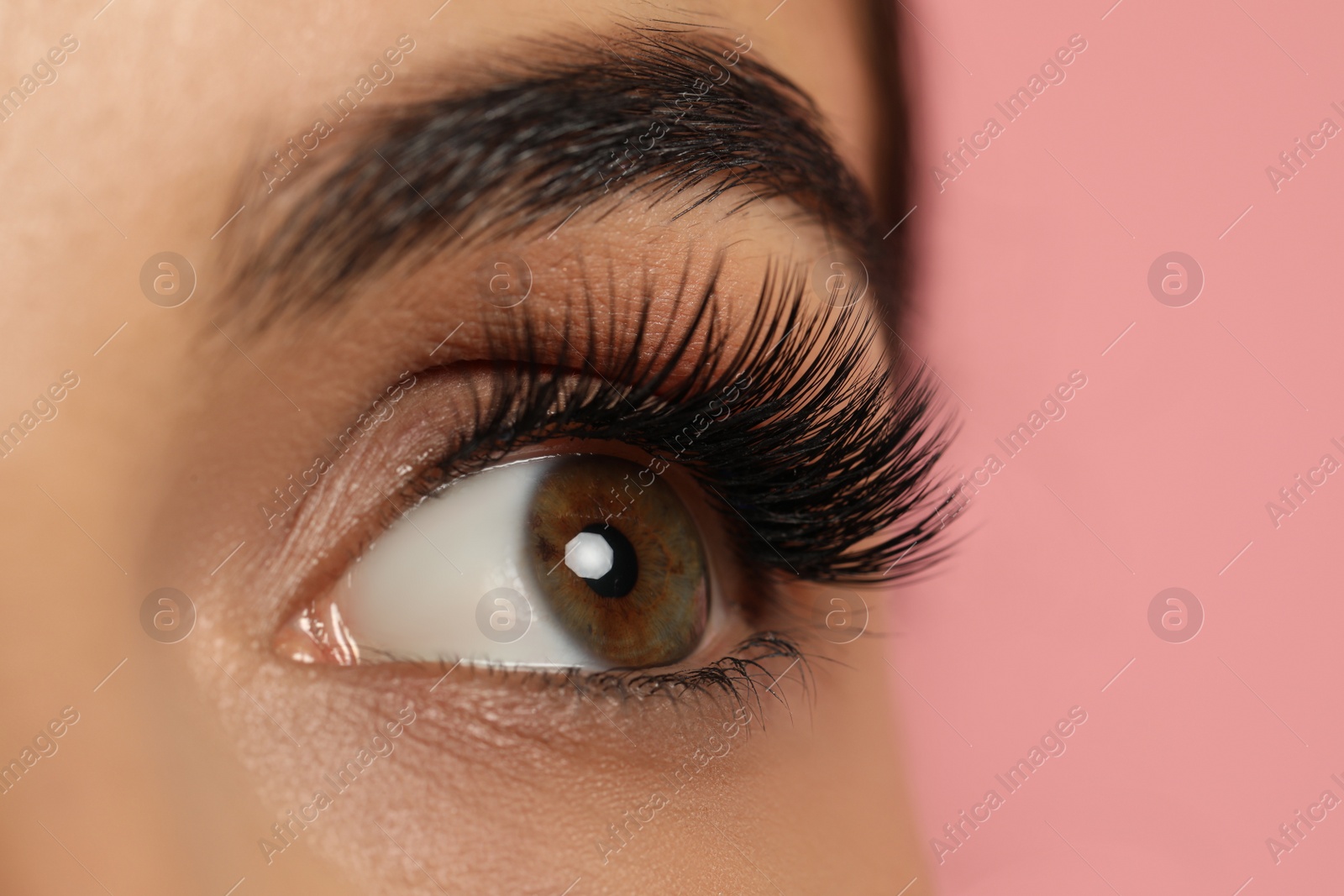 Photo of Beautiful young woman with long eyelashes on pink background, closeup