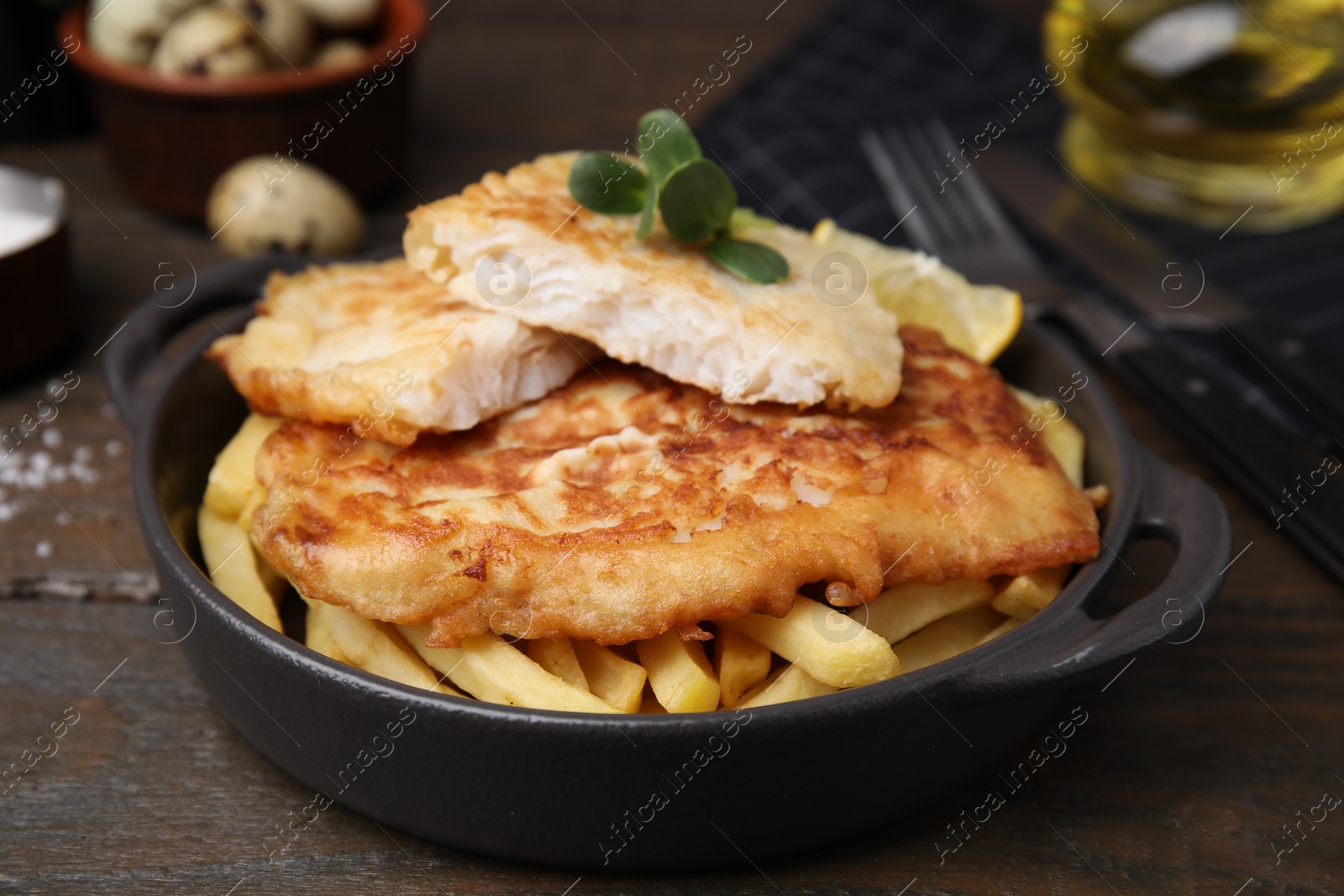 Photo of Tasty soda water battered fish and potato chips on wooden table