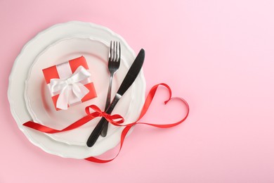 Photo of Beautiful table setting on pink background, flat lay with space for text. Valentine's Day dinner
