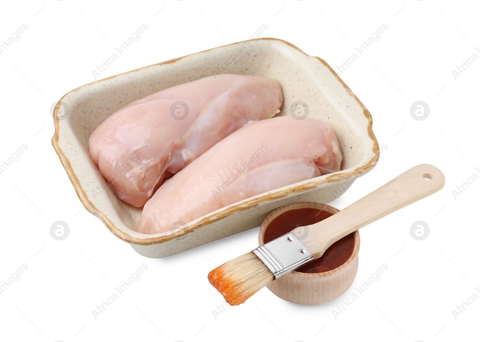 Photo of Marinade, basting brush, raw chicken fillets and chili peppers isolated on white