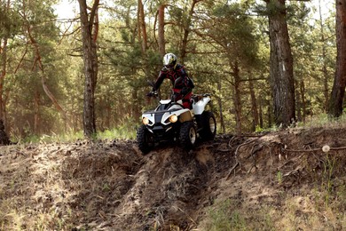 Man driving modern quad bike in forest. Extreme sport