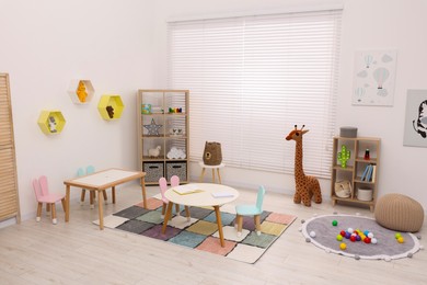 Photo of Stylish kindergarten interior with toys and modern furniture