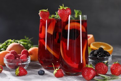 Delicious refreshing sangria and ingredients on light grey table, closeup