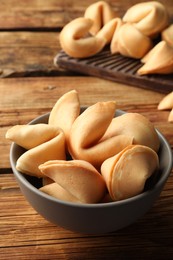 Photo of Tasty fortune cookies with predictions on wooden table