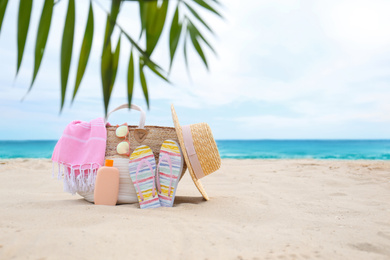 Different stylish beach objects on sand near sea. Space for text