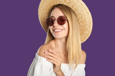 Photo of Beautiful woman in stylish sunglasses on purple background