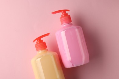 Photo of Bottles of liquid soap on pink background, flat lay