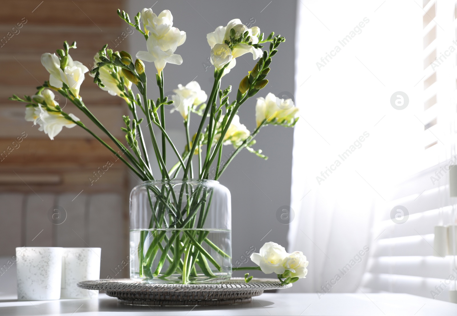 Photo of Beautiful spring freesia flowers on table in room