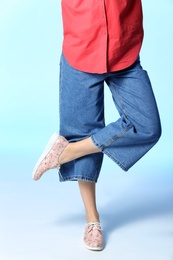 Woman in stylish shoes on color background, closeup