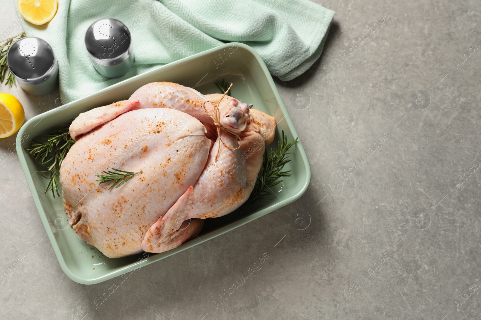 Photo of Dish with raw spiced turkey and rosemary on light background, top view. Space for text