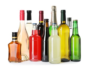 Bottles with different alcoholic drinks on white background