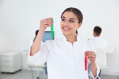 Portrait of medical student with test tubes in modern scientific laboratory