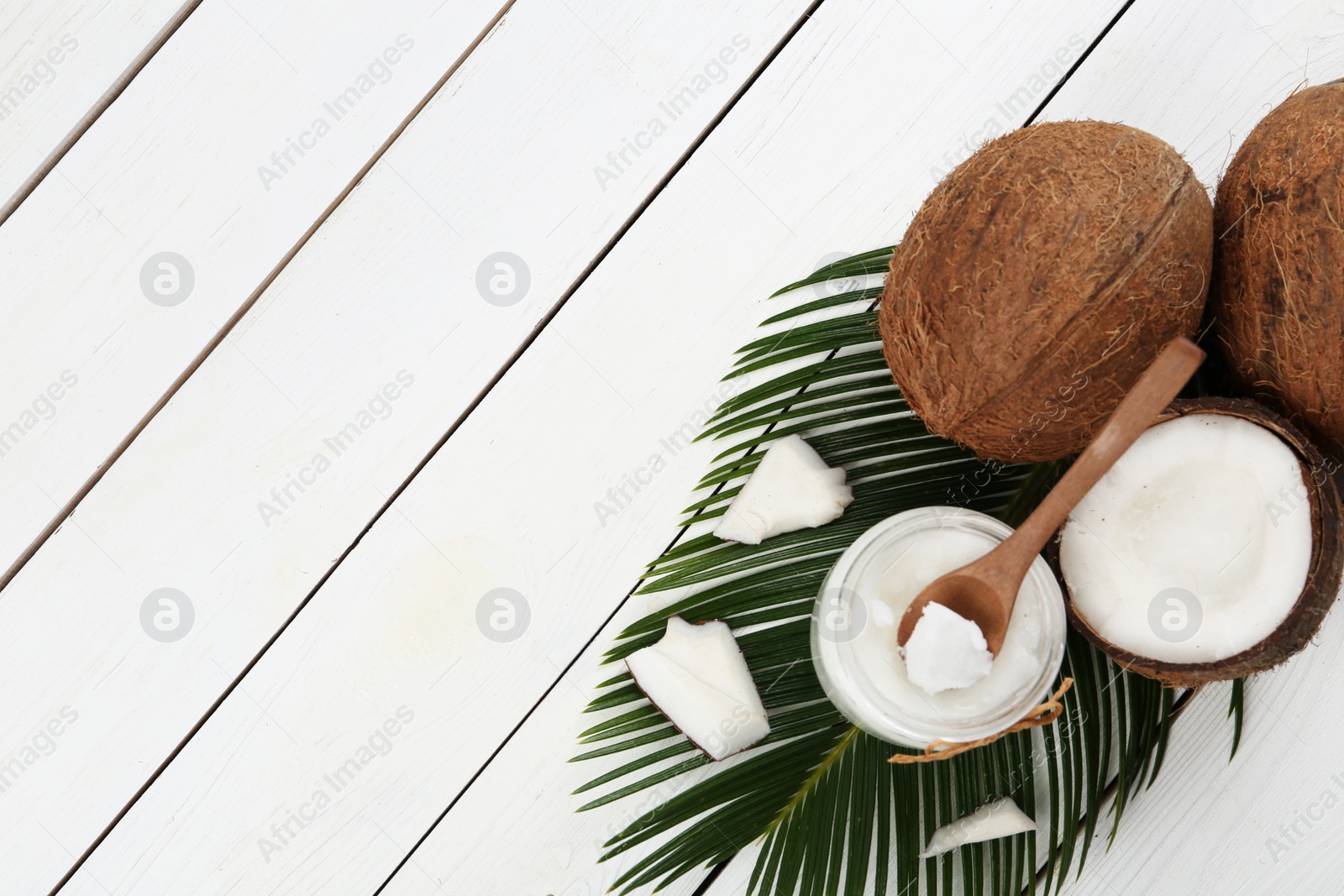 Photo of Flat lay composition with coconut oil on white wooden table, space for text. Cooking ingredients