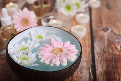 Photo of Spa composition. Bowl with water and beautiful flowers on wooden table, closeup. Space for text