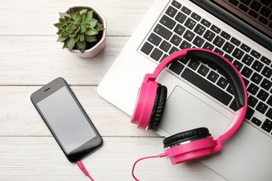 Photo of Flat lay composition with headphones, laptop and smartphone on table