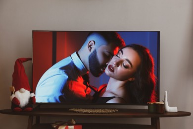 Image of Scene of romantic movie on TV in room