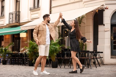 Photo of Lovely couple dancing together on city street