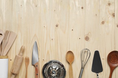 Set of different kitchen utensils on wooden table, flat lay. Space for text