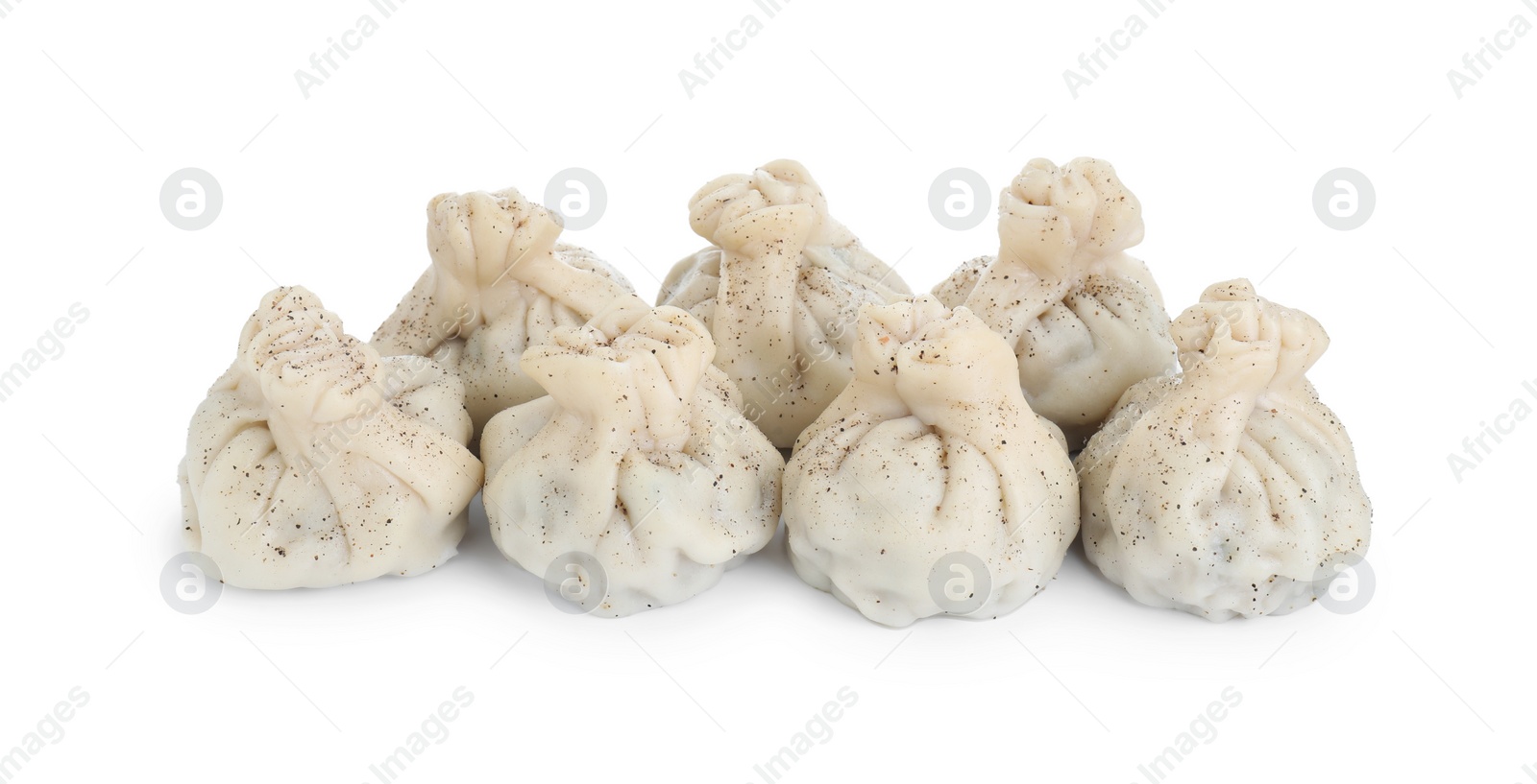 Photo of Many tasty khinkali (dumplings) and spices isolated on white. Georgian cuisine