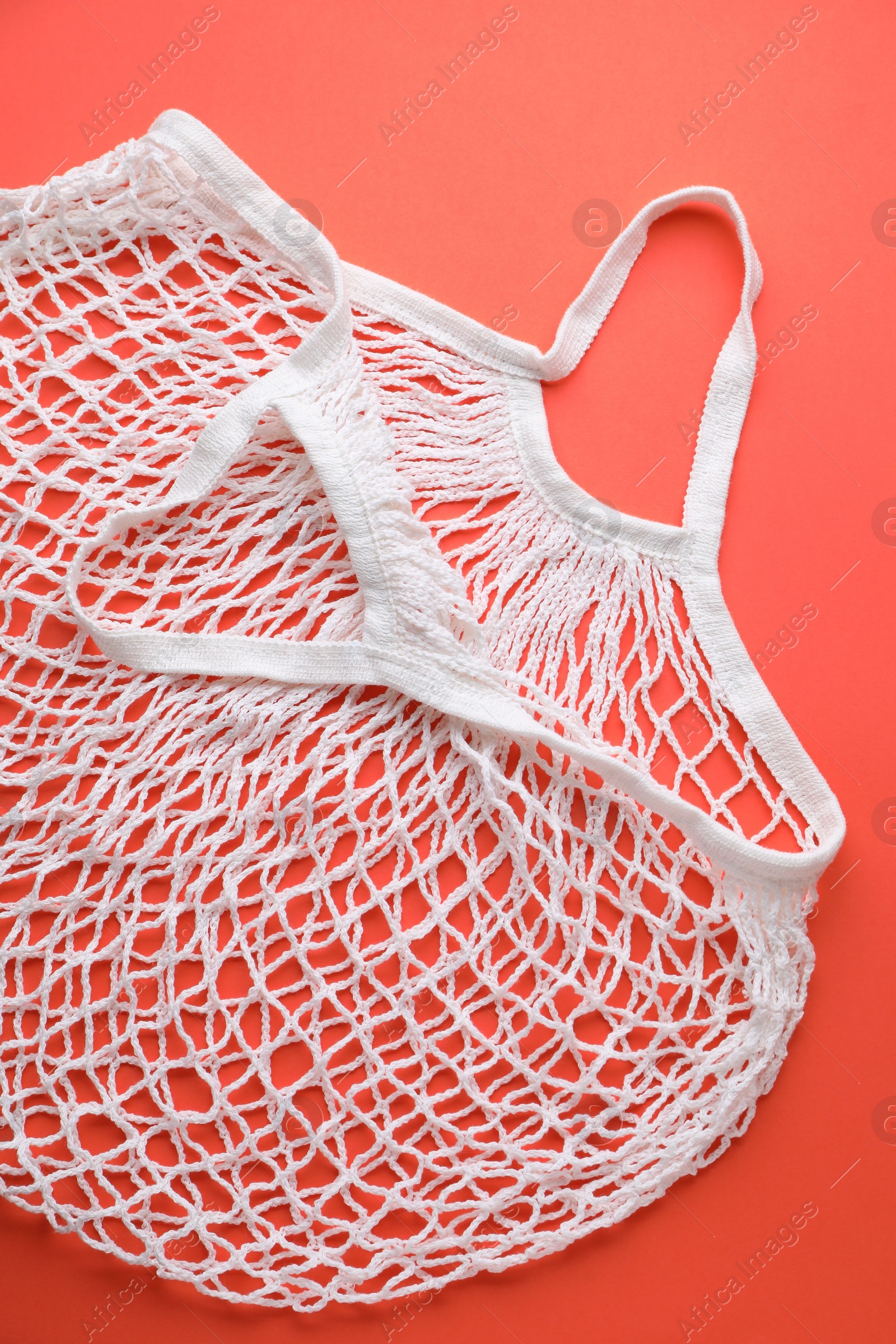 Photo of White string bag on red background, top view