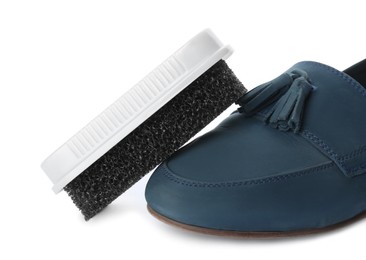 Photo of Stylish footwear and brush on white background. Shoe care accessory