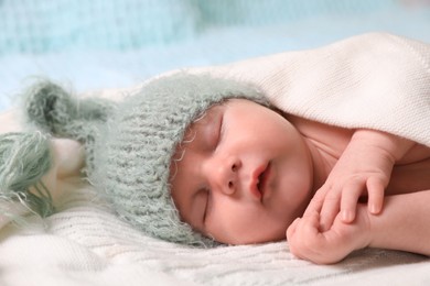 Photo of Cute newborn baby sleeping on white blanket, closeup