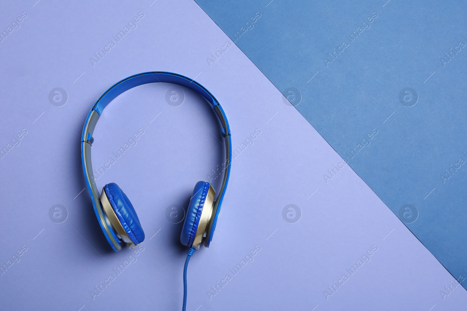 Photo of Stylish headphones on color background, top view. Space for text