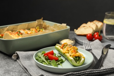 Photo of Baked stuffed zucchinis served on grey table