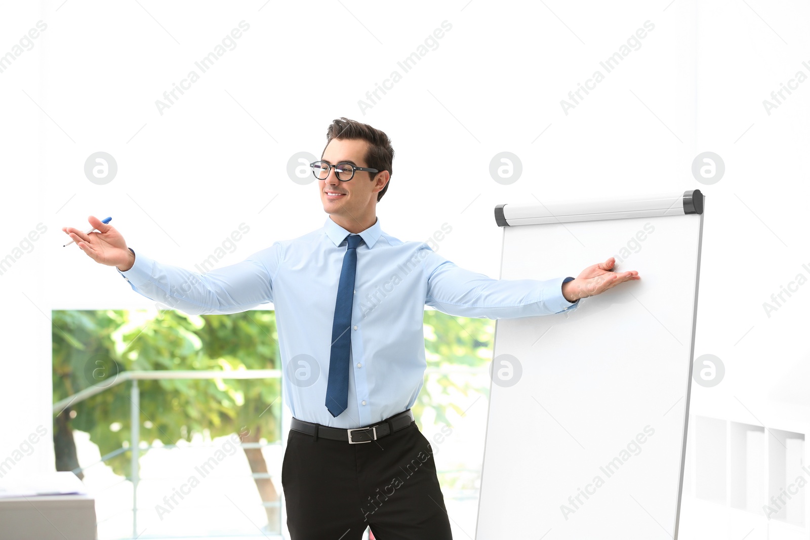 Photo of Professional business trainer near flip chart in office